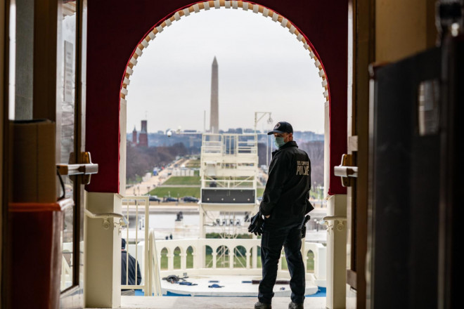 Một sĩ quan cảnh sát Capitol đứng trên cổng vòm dẫn đến sân khấu khánh thành tại Điện Capitol