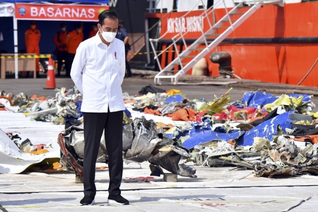 Tổng thống Indonesia Joko Widodo đứng bên cạnh những mảnh vỡ máy bay Boeing 737-500.
