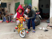 Mong ước trong năm mới của ông bố ôm con đi bán bọc chân chống xe máy