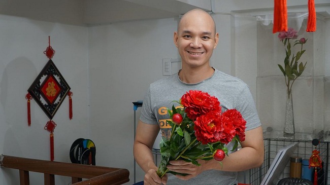 Anh Nguyễn Vĩnh Duy bên những bông hoa được làm từ bột bánh