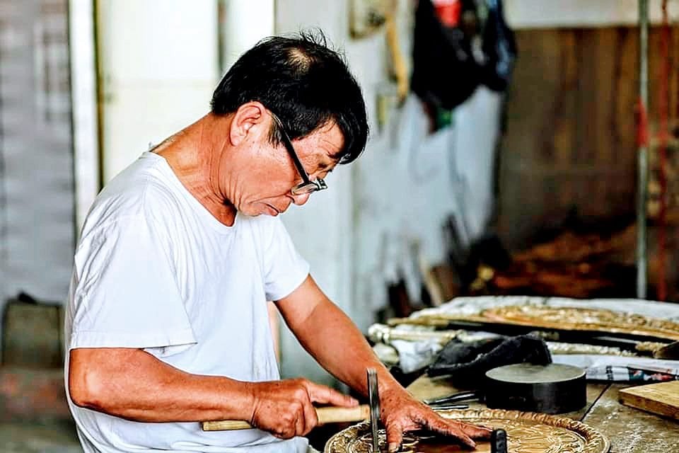 Nghệ nhân&nbsp;Đinh Quang Thắng tỉ mỉ chạm các chi tiết cho mặt đồng hồ giả cổ