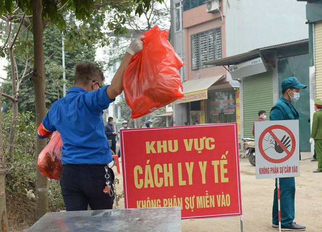 Người dân bàn giao đồ tại bàn, lực lượng thanh niên tình nguyện sẽ làm công tác vận chuyển vào một chiếc bàn khác bên trong.