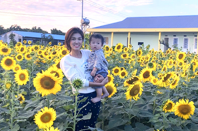 "Hoa hậu Thế giới Toàn cầu 2015" bế con trai út Quang Nhật tham qua khu vườn rộng 4 héc ta, có hơn 5000 cây hướng dương.