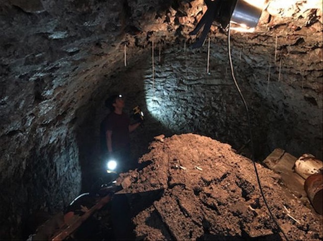 Sau khi khoan, Jake nhìn qua lỗ khoan xuống dưới. Người đàn ông này tìm thấy một đường hầm có từ năm 1900.
