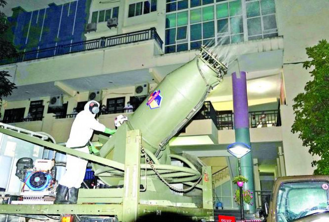 Chiến sĩ phòng hóa điều khiển “đại bác” KTH-20 phun hóa chất diệt COVID-19 tại một tòa nhà cao tầng trong Bệnh viện Bạch Mai, tháng 3/2020 - ẢNH: NGUYỄN MINH