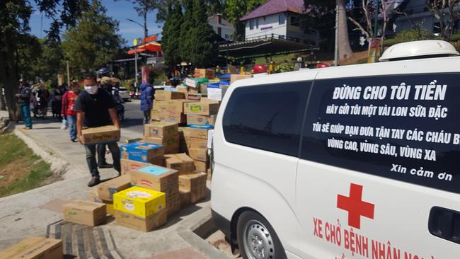 Nhiều thùng sữa, phở gói, mì tôm đã được trao tặng, tập kết bên cạnh chiếc xe cứu thương quen thuộc của ông Đoàn Ngọc Hải.