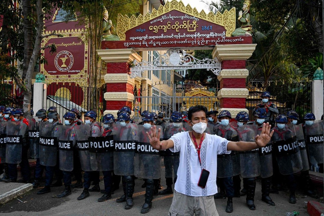 Cảnh sát Myanmar đứng chắn trước một ngôi đền, là nơi tập trung những người ủng hộ quân đội.