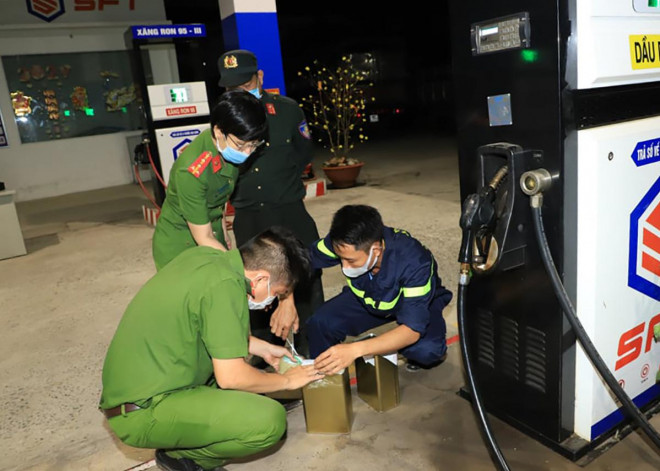 Cảnh sát lấy mẫu xăng trong đường dây buôn lậu, sản xuất xăng giả của Hữu. Ảnh: Thái Hà.