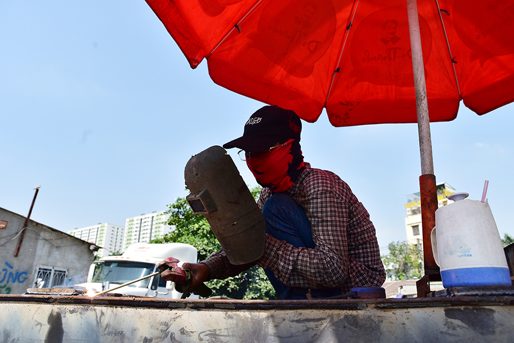 “Vào thời điểm gần trưa và đầu giờ chiều nếu không có dù che nắng thì hơi hàn và thép từ rơ moóc phả lên rát mặt lắm. Mấy hôm nay trời nắng công việc hàng ngày của chúng tôi càng thêm cực nhọc, nhanh xuống sức”, ông Trần Xuân Kim, thợ hàn bên Xa lộ Hà Nội, TP Thủ Đức cho hay.