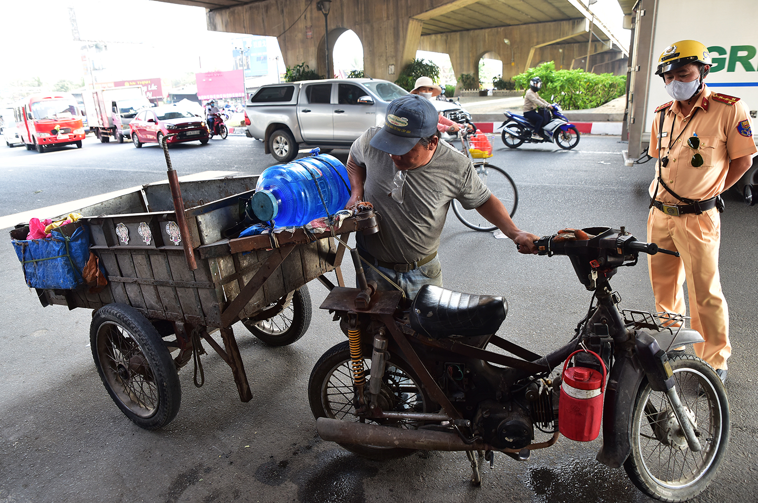 Ông Trần Văn Đoàn phải tháo rời thùng phía sau, giao chiếc xe “nhiều không” của mình để CSGT thu giữ sau khi bị lập biên bản vi phạm.