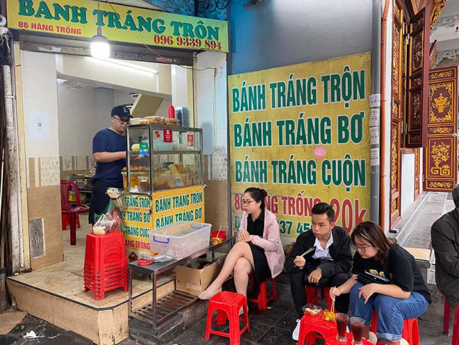 Các bạn trẻ thưởng thức món bánh tráng trộn lúc xế chiều. Ảnh: Hồng Vân