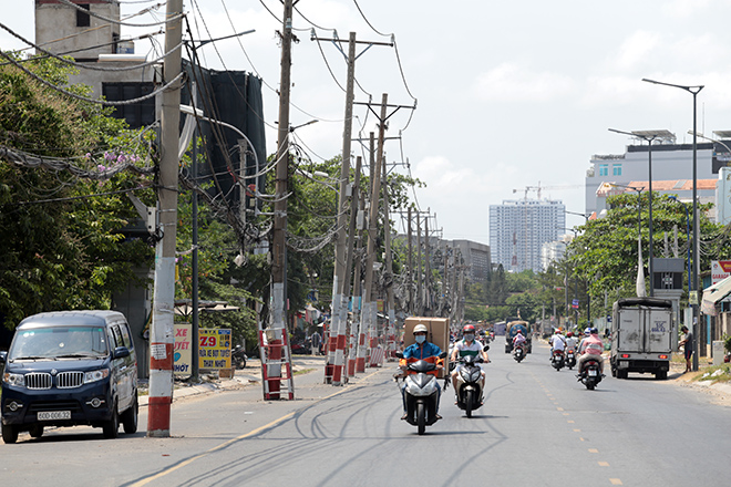 Theo người dân, việc hàng cột điện đứng giữa đường gây cản trở giao thông và có nguy cơ gây tai nạn, một số cột điện còn nghiêng vào nhà khiến người dân lo lắng.