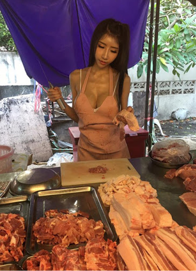 Mặc chiếc áo yếm "buông lơi" vòng 1 "chơi vơi", hot girl bán thịt lợn thu hút nhiều sự chú ý của khách mua hàng.
