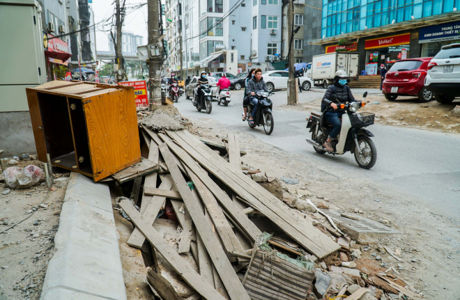 Vật liệu xây dựng, đồ đạc cũ vứt bừa bãi xuống lòng đường, vỉa hè