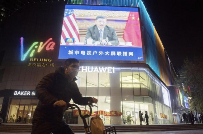 Màn hình lớn trên đường phố Bắc Kinh phát thông tin hội đàm trực tuyến giữa Tổng thống Mỹ Joe Biden và Chủ tịch Trung Quốc Tập Cận Bình. Ảnh - Kyodo
