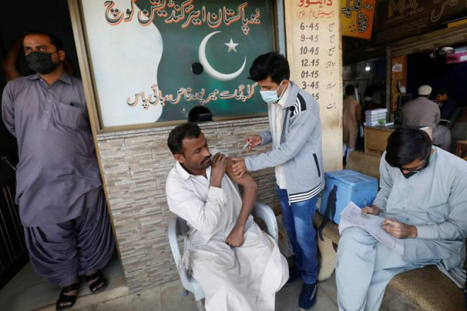 Người dân Pakistan được tiêm vaccine COVID-19 ở TP Karachi ngày 16-12-2021. Ảnh: REUTERS