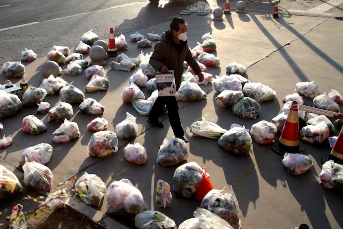 Một nhân viên giao thực phẩm cho cư dân tại khu phong tỏa ở thành phố Tây An, Trung Quốc hôm 29/12/2021. Ảnh: Reuters