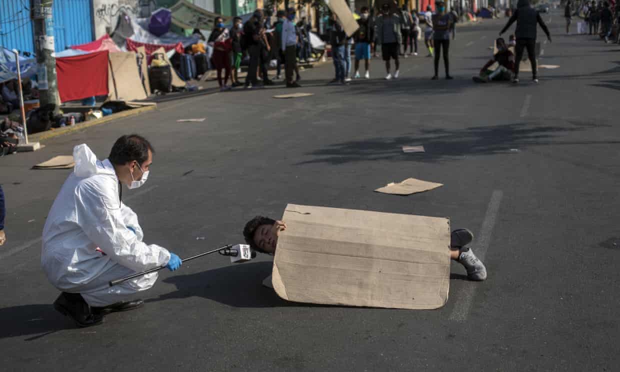 Thanh niên ở Peru nằm giữa đường để phản đối lệnh hạn chế đi lại trong dịch Covid-19 của chính phủ (ảnh: Guardian)
