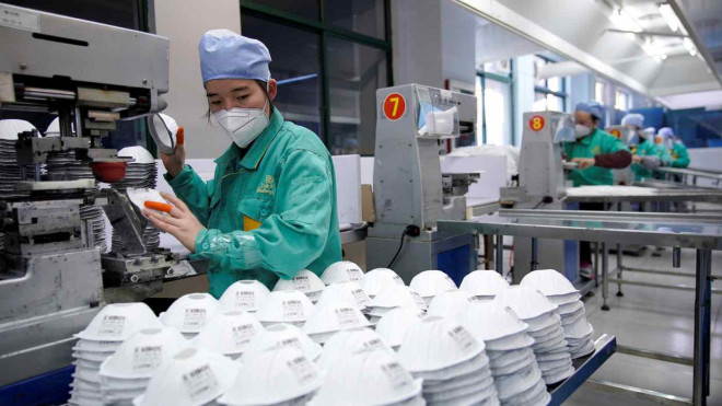 Công nhân làm việc tại nhà máy sản xuất khẩu trang ở TP Thượng Hải - Trung Quốc. Ảnh: REUTERS
