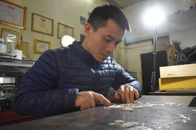 Nghệ nhân Quách Phan Tuấn Anh đang thực hiện tranh đậu bạc linh vật hổ