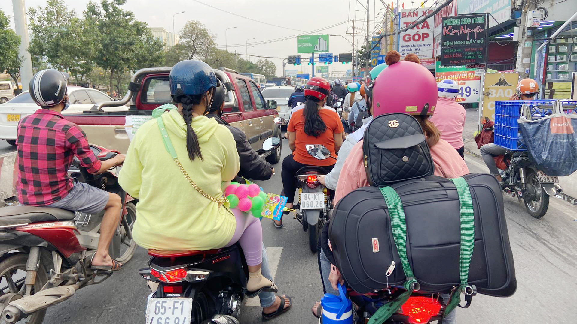 Nhiều người chạy xe máy chở lỉnh kỉnh đồ đạc, quà Tết về quê.