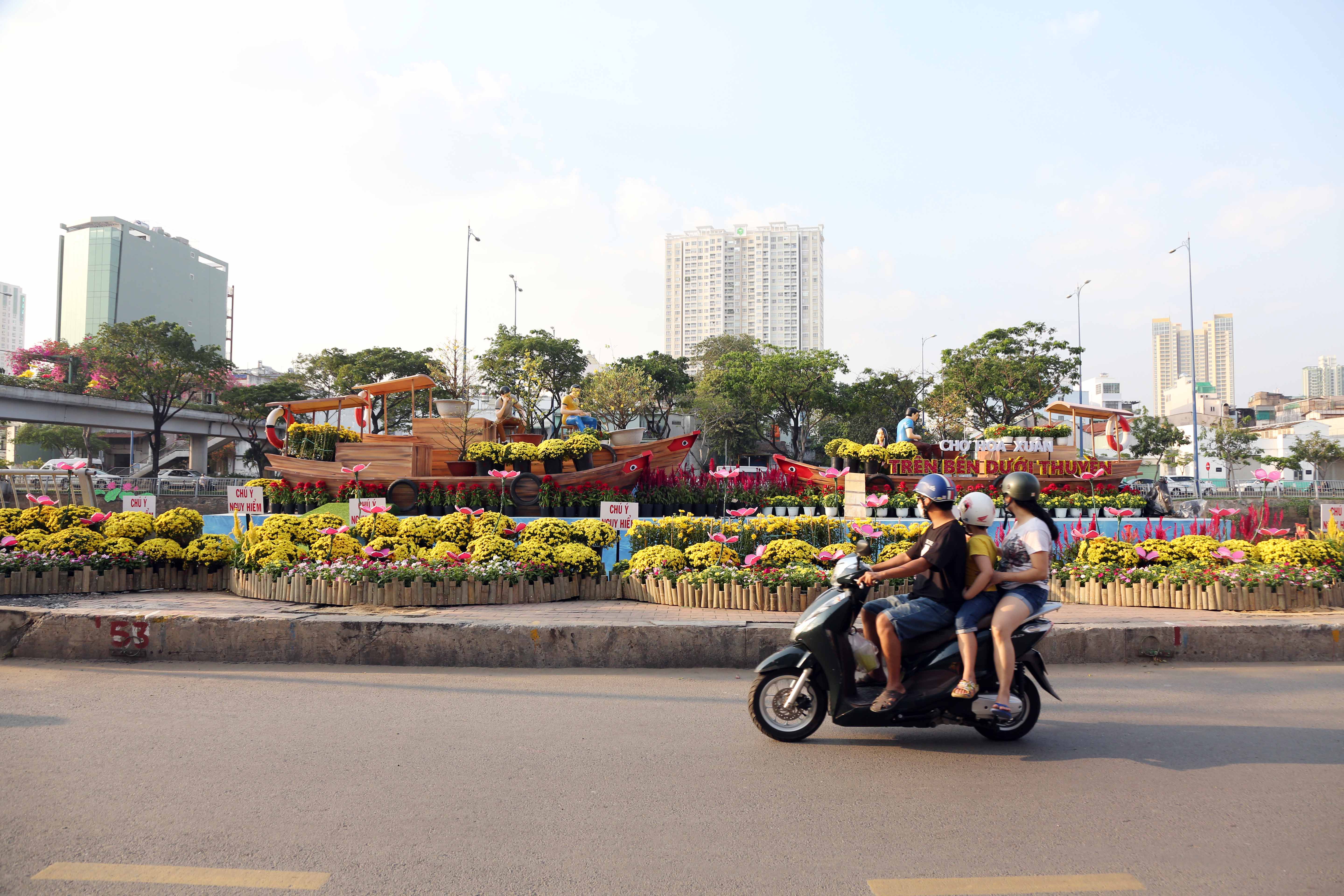 Dọc hai cầu đi bộ bắc ngang kênh Tàu Hủ, dọc đường Bến Bình Đông khu vực diễn ra chợ hoa xuân có những tiểu cảnh trang trí nhiều để người dân TP có thể đi dạo lẫn mua cho mình cành mai, chậu cúc…