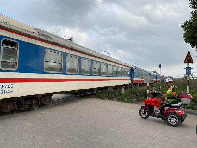 Ông luôn nhắc nhở người dân dừng lại khi có tàu chạy qua.