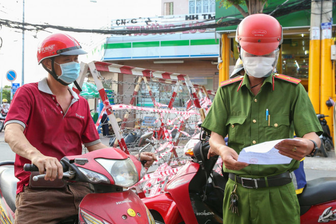 Trong giai đoạn này, người dân khi lưu thông phải có giấy đi đường. Trong ảnh: Lực lượng chức năng kiểm tra giấy đi đường của người dân; ảnh Hoàng Triều