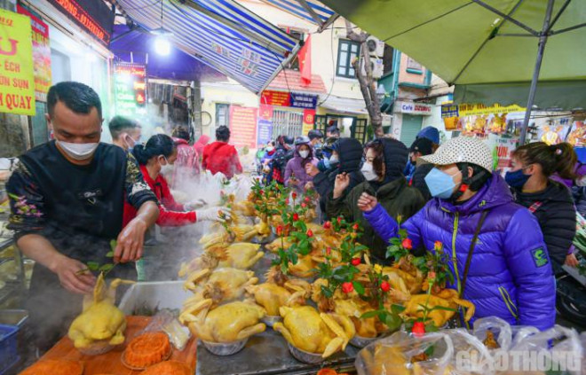 Ngay từ sớm, khu vực phố Gia Ngư, chợ Hàng Bè đã tấp nập người mua sắm. Trong đó, đông đúc nhất vẫn ở những cửa hàng bán gà ngậm hoa hồng cho mâm cúng Giao thừa.