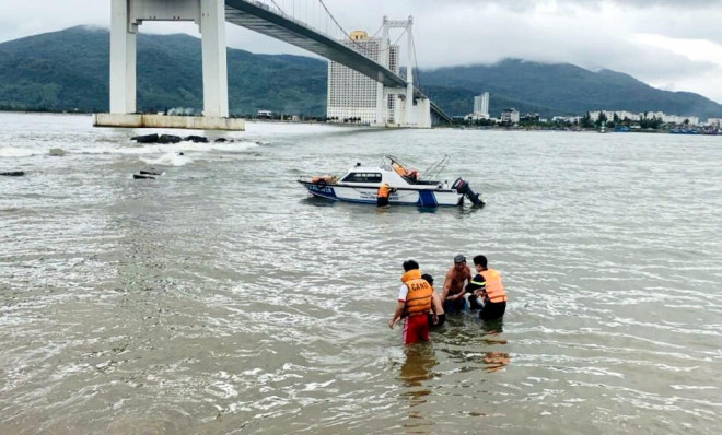 Cảnh sát PCCC và CNCH cùng ngư dân đưa nạn nhân lên bờ.