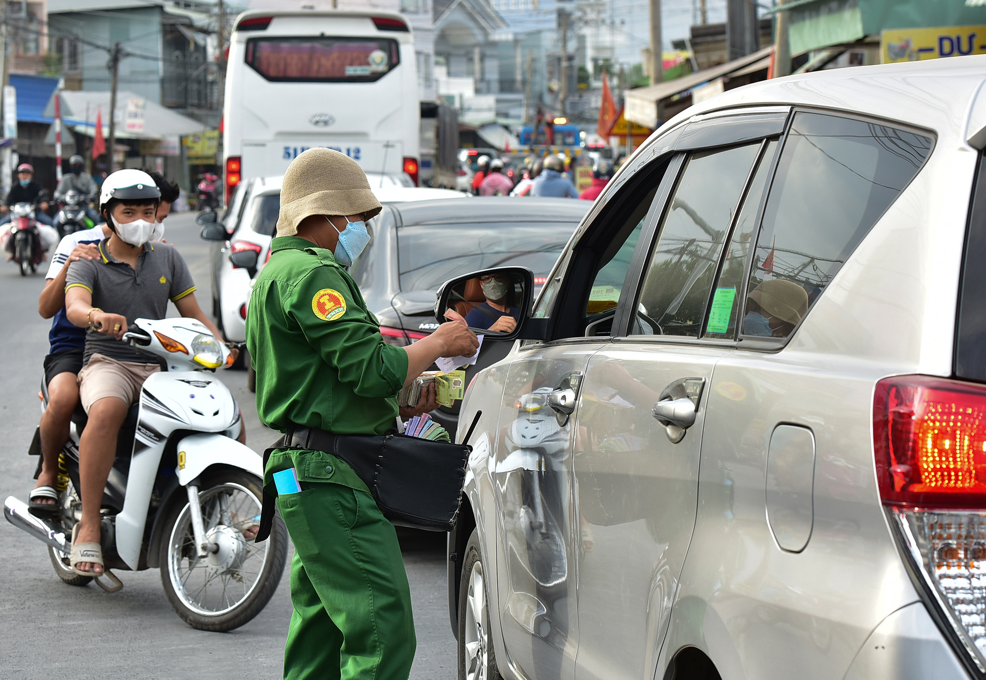 Nhân viên bán vé cho ôtô qua phà phải di chuyển cách phà hơn 1km để bán cho khách.