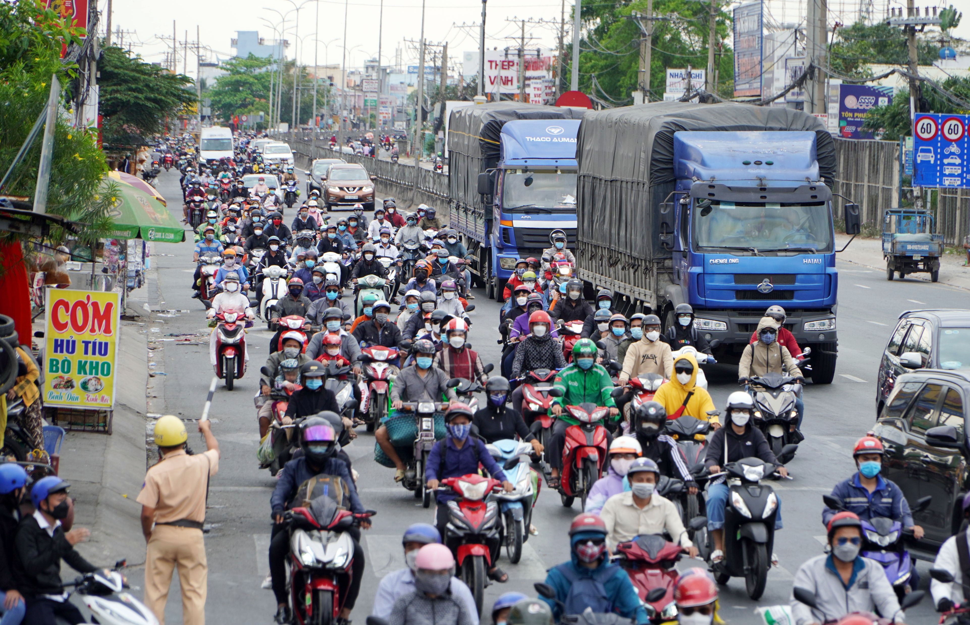 Ghi nhận trên tuyến Quốc lộ 1 (huyện Bình Chánh, TP.HCM) dòng xe máy nối đuôi nhau di chuyển.