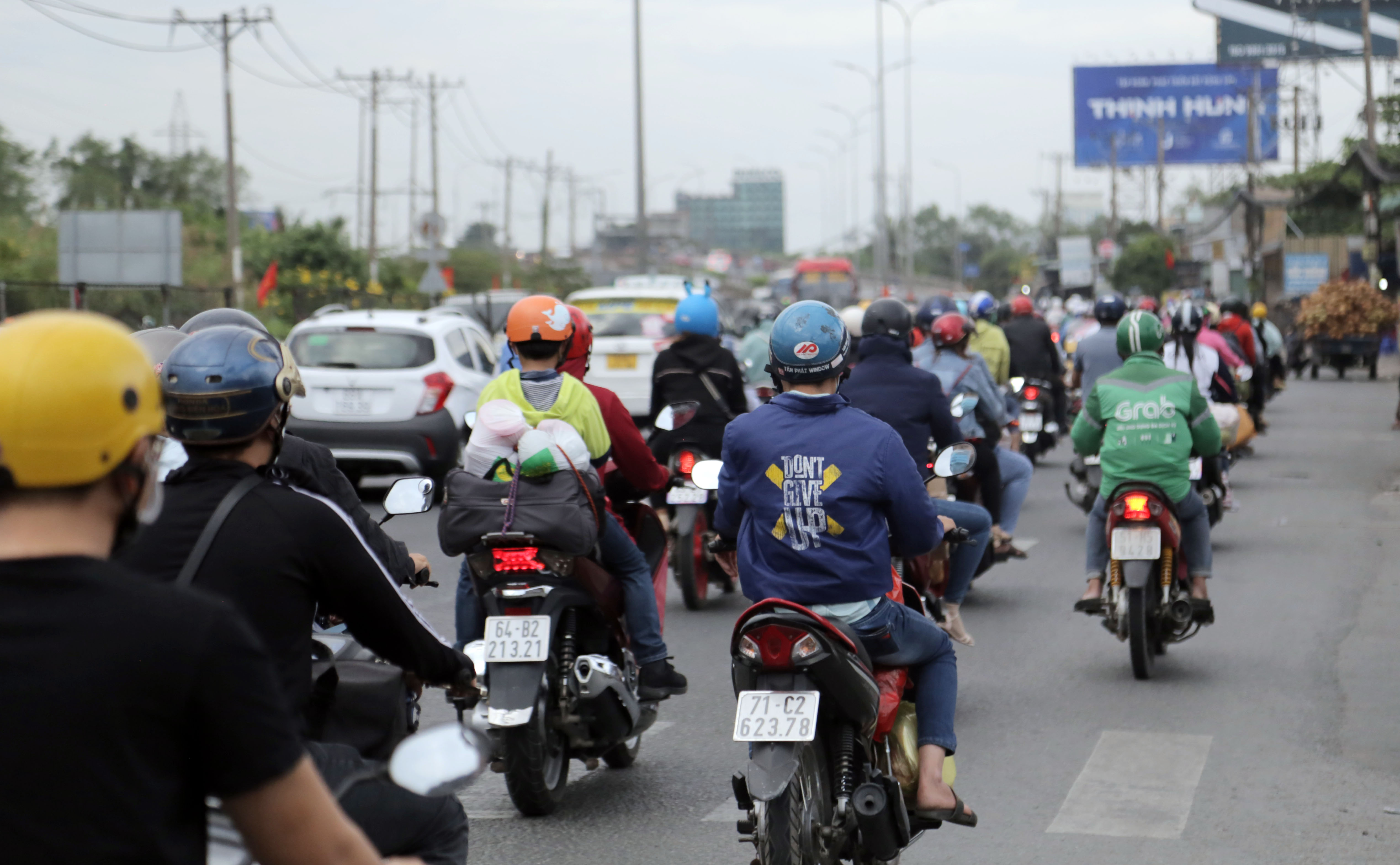 Dòng phương tiện xe máy nối đuôi nhau di chuyển trên Quốc lộ 1 (huyện Bình Chánh) hướng về quận Bình Tân.