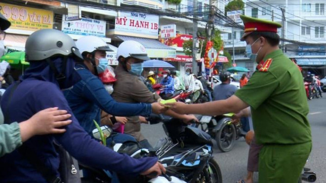 Công an TP Châu Đốc phát Cẩm nang phòng chống tội phạm cho người dân trước cổng vào khu vực Miếu Bà