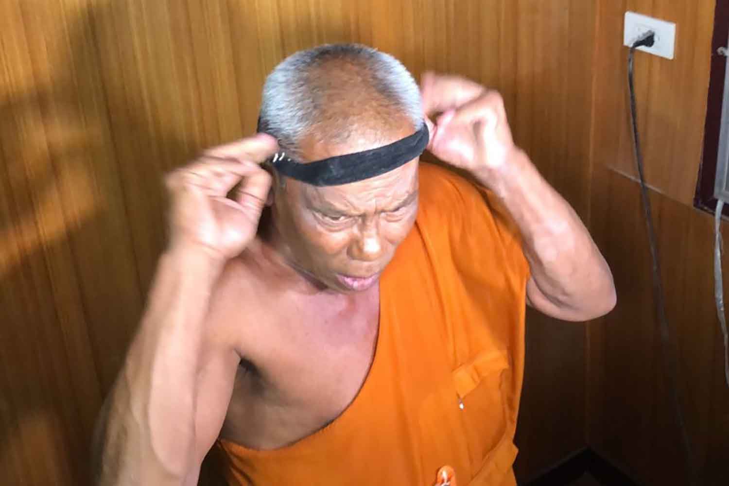 Sư trụ trì Prasartporn Mahapunyo cố biện minh "làm giảm đau đầu" bằng cách dùng băng đô tối 9/2. Ảnh: Bangkok Post
