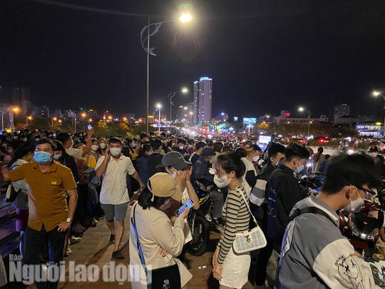 Hàng ngàn người tập trung ở khu vực đầu cầu Rồng - quận Sơn Trà, TP Đà Nẵng để chờ xem cầu phun lửa, phun nước trong đêm đầu tiên tổ chức lại hoạt động này. Vì lý do dịch Covid-19, đã nhiều tháng liền, "đặc sản" phun lửa, phun nước bị tạm dừng