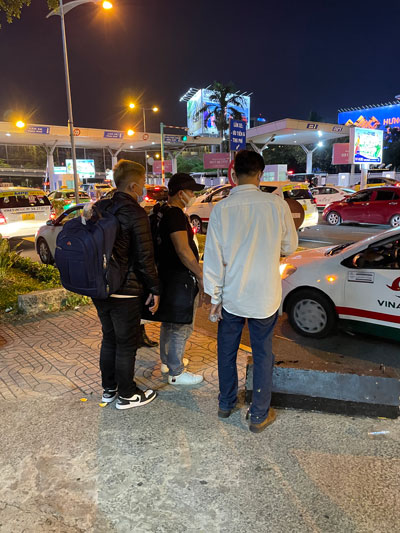 “Cò” taxi (mặc áo trắng) đang ra giá với nhóm khách đi Tây Ninh .Ảnh: THU HỒNG