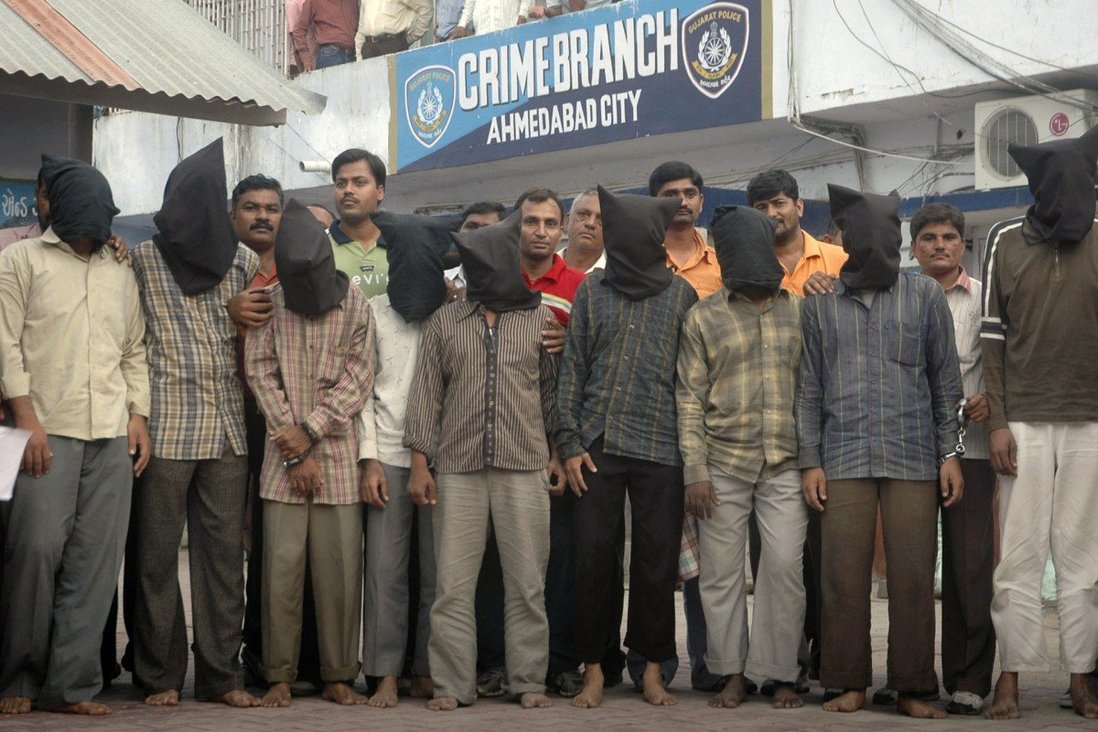 Một số nghi phạm khủng bố ở thành phố Ahmedabad bị bịt kín đầu sau khi bị cảnh sát bắt giữ (ảnh: SCMP)