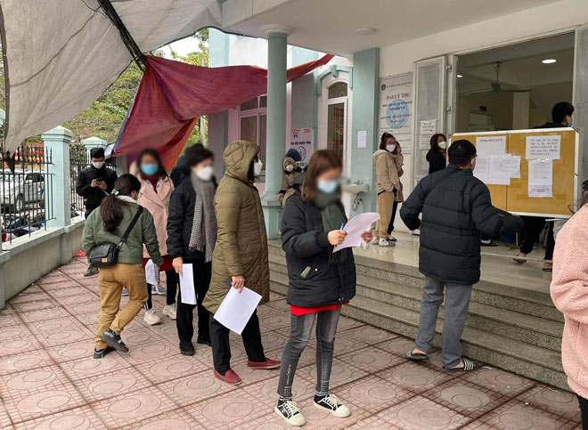 Người dân ra trạm y tế phường Hoàng Liệt (Hoàng Mai, Hà Nội) xếp hàng chờ xét nghiệm COVID-19 lại sau khi test nhanh dương tính tại nhà