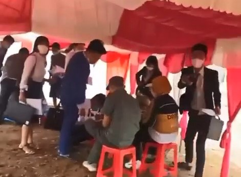 Trong khung rạp, một nhóm "cò" đang viết biên nhận cho khách hàng chốt cọc. Ảnh: Cắt từ clip