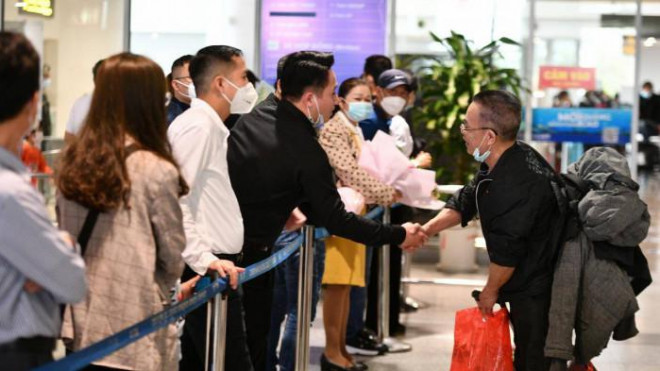Hành khách tại sân bay hỏi thăm người Việt tại Ukraine vừa được đưa trở về quê hương