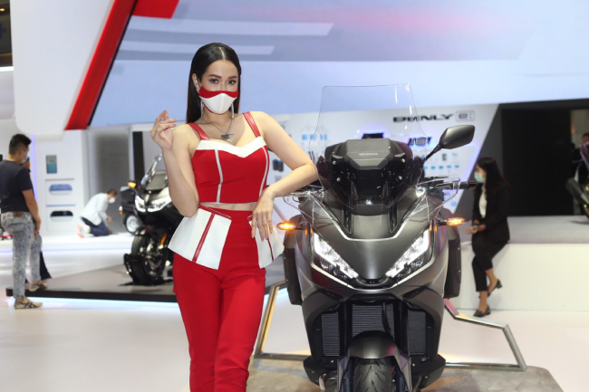 Người đẹp khoác bộ đồ đỏ để lộ vai tràn nõn nà bên xe mới của Honda ở Motor Show 2022.&nbsp;
