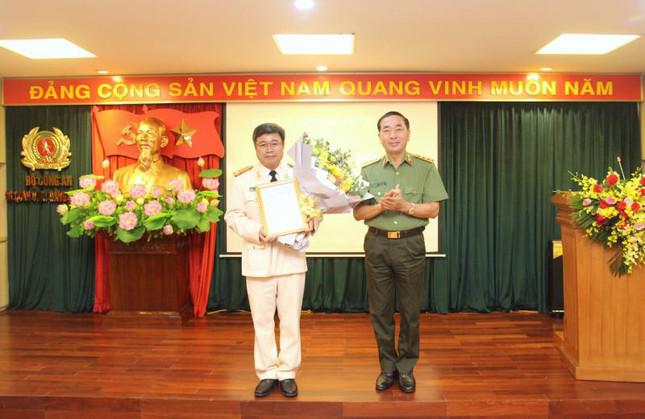 Thứ trưởng Trần Quốc Tỏ trao Quyết định của Ban Bí thư và tặng hoa chúc mừng đại tá Lê Minh Hà. Ảnh: CAND
