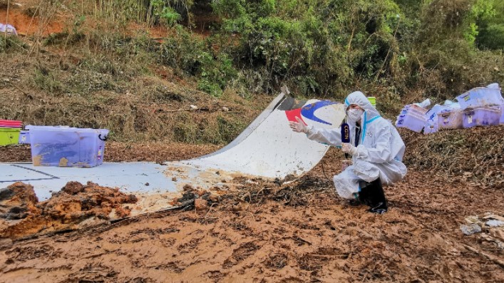 Một phóng viên Trung Quốc đưa tin về vụ rơi máy bay tại hiện trường. Ảnh: CGTN