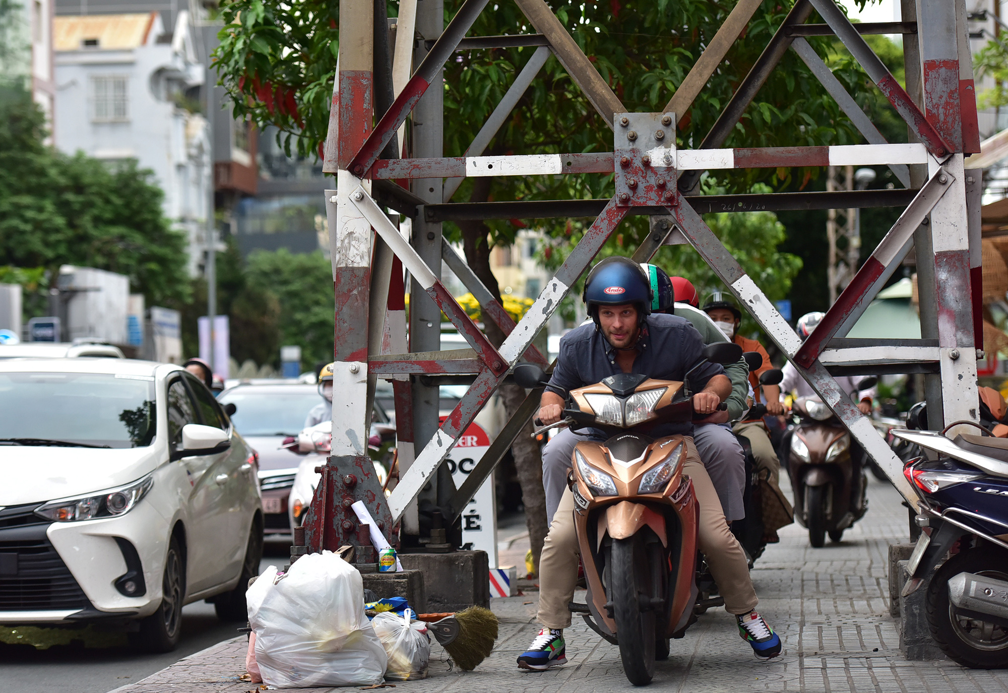 Nhiều người điều khiển xe máy chạy len lỏi giữa các làn ô tô, số khác kéo nhau chạy lên vỉa hè luồn lách, chui dưới cột điện… để thoát kẹt xe.