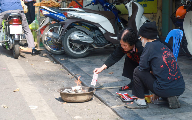 Nhiều người cao tuổi tranh thủ hàn huyên câu chuyện trong lúc hoá vàng tiễn ông Công ông Táo.