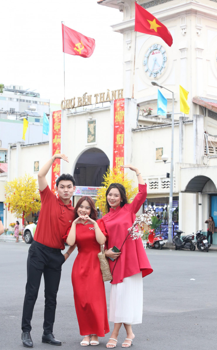 Bạn trẻ TPHCM diện áo dài rực rỡ chụp ảnh trước chợ Bến Thành - hình ảnh 3