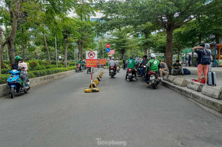 Những ngày qua, khu vực đón trả khách của các tài xế xe ôm công nghệ tại lối ra vào gần bãi giữ xe sân bay đều chật kín người xách vali lỉnh kỉnh nhưng trong chiều 20/1 nơi này thưa thớt.