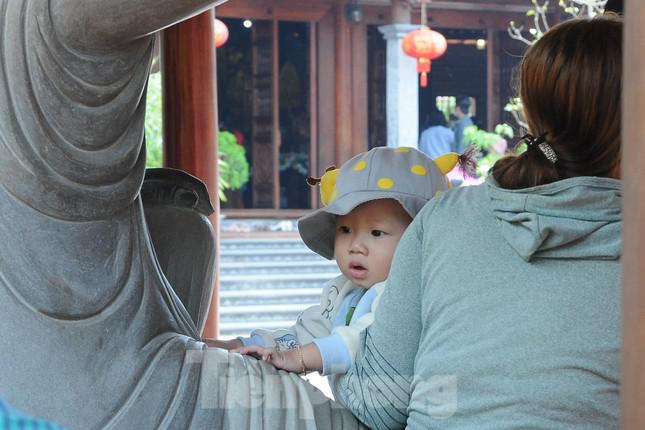 Một em bé đang "nghỉ giải lao" cùng mẹ bên tượng Phật.