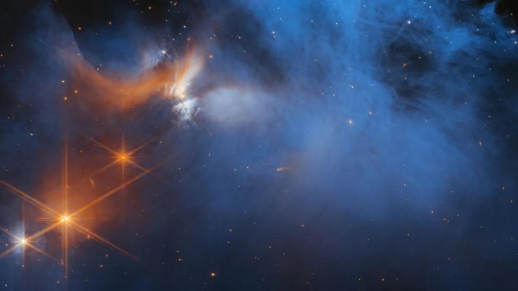 Một đám mây khí phân tử mỏng màu xanh với các đốm phát sáng từ các ngôi sao ở xa - Ảnh: James Webb/NASA/ESA/CSA